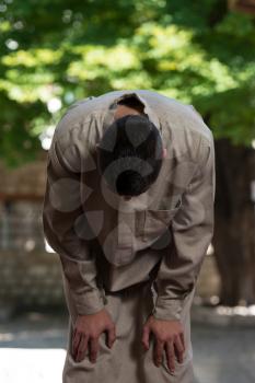 Young Muslim Man Making Traditional Prayer To God While Wearing A Traditional Cap Dishdasha