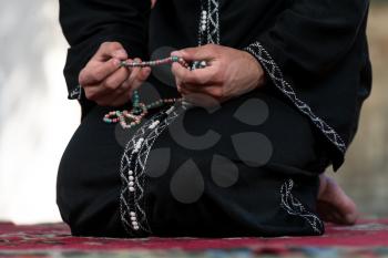 Young Muslim Man Making Traditional Prayer To God While Wearing A Traditional Cap Dishdasha