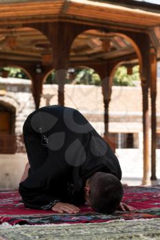 Young Muslim Man Making Traditional Prayer To God While Wearing A Traditional Cap Dishdasha