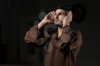 Young Muslim Man Making Traditional Prayer To God While Wearing A Traditional Cap Djellaba