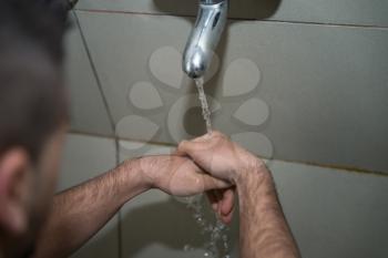 Muslim Man Preparing To Take Ablution In Mosque