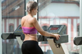 Young Attractive Girl Exercise In Fitness Club On Step Machine