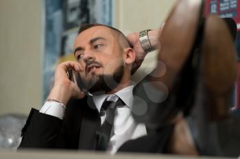 Relaxed Businessman Kicks Back With His Feet Up