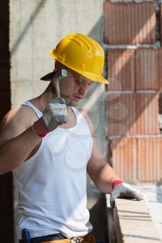 A Handsome Construction Man Using A Hammer To Nail Together Wood