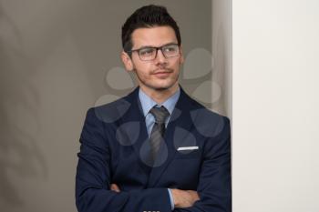 Portrait Of Handsome Confident Young Businessman Standing Arms Crossed
