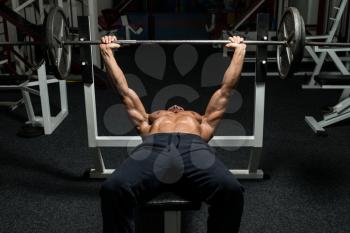 Mature Man In Gym Exercising On The Bench Press