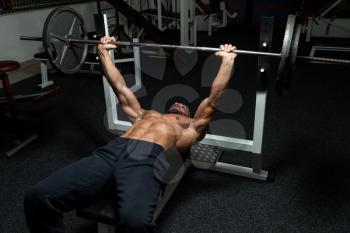 Mature Man In Gym Exercising On The Bench Press