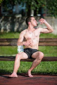 Young Muscular Men Drinking A Water Bottle