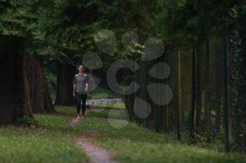 Young Woman Running In Wooded Forest Area - Training And Exercising For Trail Run Marathon Endurance - Fitness Healthy Lifestyle Concept