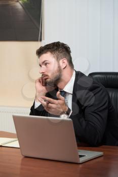 Young Businessman Working In His Office While Talking On The Phone