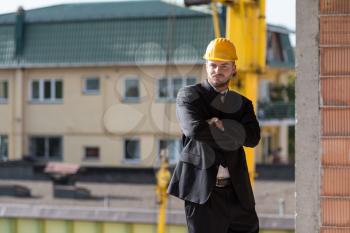 Portrait Of Business Man With Yellow Helmet On Construction