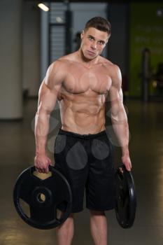 Portrait Of A Physically Fit Man Holding Weights In Hand