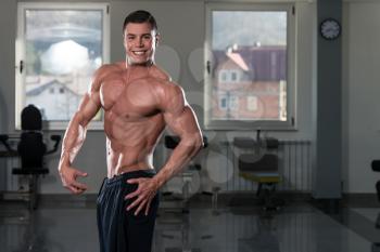 Portrait Of A Physically Fit Man Showing His Well Trained Body In Gym