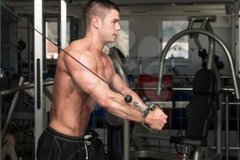 Young Bodybuilder Is Working On His Chest With Cable Crossover In A Dark Gym