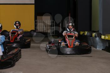 Group Of People Is Driving Go-Kart Car With Speed In A Playground Racing Track - Go Kart Is A Popular Leisure Motor Sports