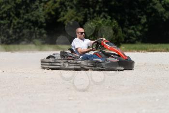 Young Man Is Driving Go-Kart Car With Speed In A Playground Racing Track - Go Kart Is A Popular Leisure Motor Sports