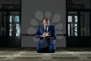 Muslim Businessman Reading Holy Islamic Book Koran In The Mosque