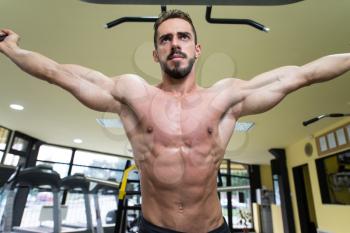 Young Man Bodybuilder Is Working On His Chest With Cable Crossover In A Gym