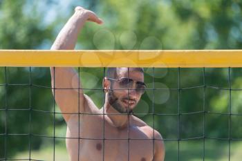 Muscular Young Man Playing Beach Volleyball Diving After The Ball