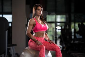 Young Mexican Woman Resting On Ball After Working Out In Fitness Cente