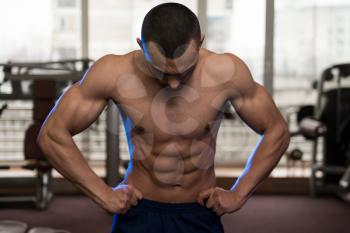 Portrait Of A Physically Fit Man Showing His Well Trained Body In Gym