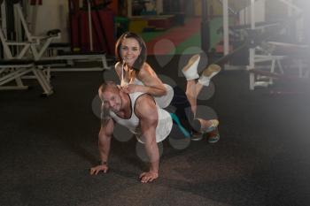 Couple Doing Pushups As Part Of Bodybuilding Training In The Gym