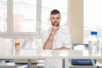 Portrait Of A Caucasian Student In A Chemistry Lab Smiling And Looking In The Camera With Hands Folded