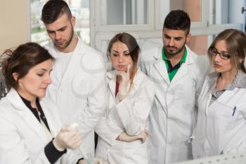 Group Of Students Scientists Conducting Research With Teacher In A Lab Environment Classroom Learning Lessons - Get Help And Support