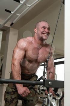 Muscular Man Doing Heavy Weight Exercise For Triceps On Machine In Gym