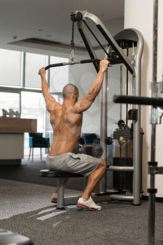 Young Bodybuilder Doing Heavy Weight Exercise For Back On Machine