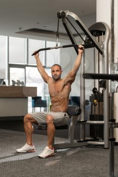 Young Bodybuilder Doing Heavy Weight Exercise For Back On Machine