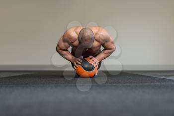 Young Man Exercise With Medical Ball In Fitness Club