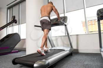 Handsome Man Running On The Treadmill In Gym