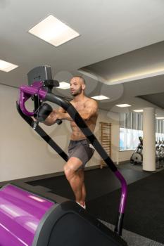 Handsome Man Exercising On A Stepper In Gym