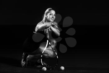 Female Tennis Player With Racket Ready To Hit A Tennis Ball - Isolated On Black