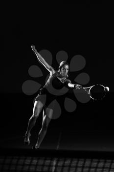 Female Tennis Player With Racket Ready To Hit A Tennis Ball - Isolated On Black