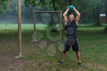 Fitness Man Lifting Kettlebell Workout Exercise Outdoors In Nature