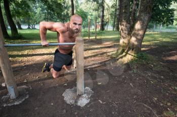 Young Athlete Working Out Triceps In An Outdoor Gym - Doing Street Workout Exercises
