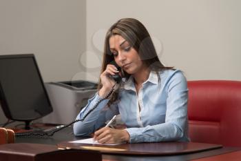 Beautiful Young Woman Working Taking Notes And Talking On Phone- Businesswoman Working Online