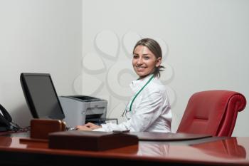 Portrait Of A Young Female Doctor Using Computer At Office - Healthcare Worker Working Online