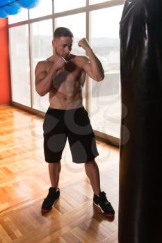 Young Man Boxing On Bag - Boxing In A Gym - The Concept Of A Healthy Lifestyle - The Idea For The Film About Boxing