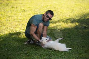 Man And German Spitz Sitting In The Park - Together Enjoying The View - Playing Around