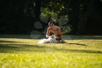 Man And German Spitz Sitting In The Park - Together Enjoying The View - Playing Around