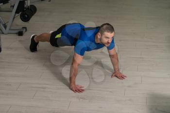 Personal Trainer Doing Pushups On Floor In Gym As Part Of Bodybuilding Training