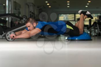 Personal Trainer Doing A Exercise For Abs With Bosu Balance Ball As Part Of Bodybuilding Fitness Training