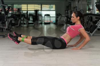 Attractive Woman Exercising With A Resistance Band On Floor In Gym As Part Of Fitness Training