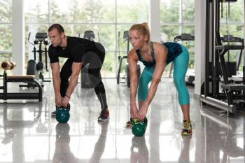 Fitness Woman And Man Working With Kettle Bell In A Gym - Kettle-bell Exercise