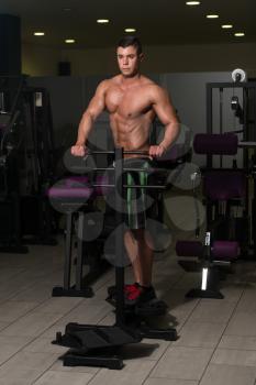 Young Healthy Man Exercising Abdominals On Machine