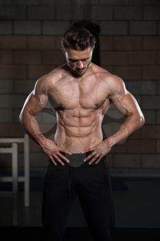 Handsome Man Standing Strong In The Gym And Flexing Muscles - Muscular Athletic Bodybuilder Fitness Model Posing After Exercises