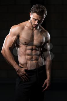 Handsome Man Standing Strong In The Gym And Flexing Muscles - Muscular Athletic Bodybuilder Fitness Model Posing After Exercises